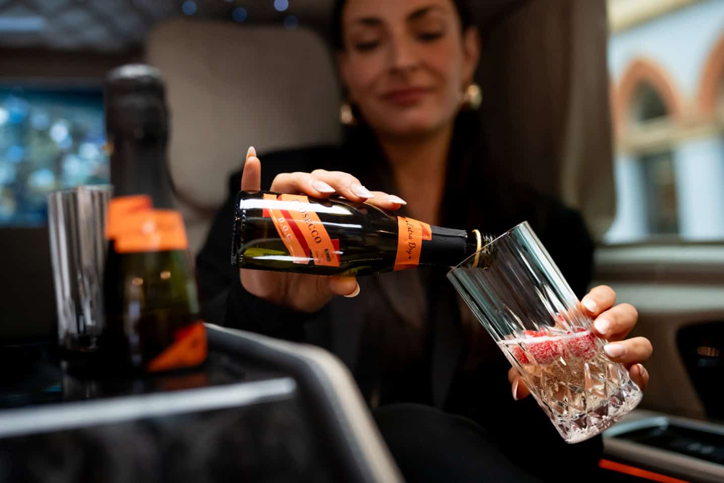Luxury Travel Experience with Champagne Service Elegant woman pouring champagne into a glass during luxury travel.