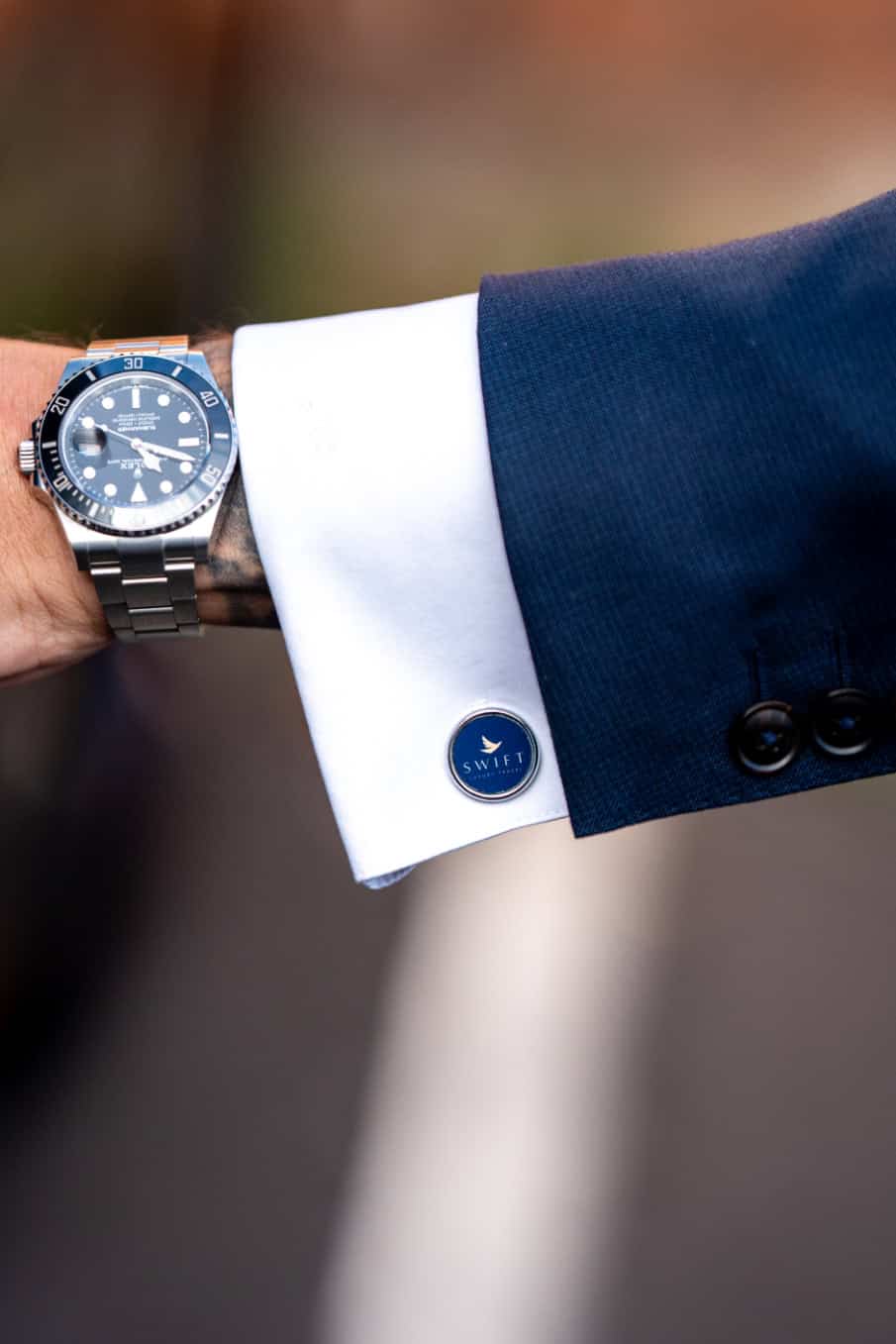 Swift Luxury Travel-37 Luxury watch on a man's wrist with a navy suit and white shirt.