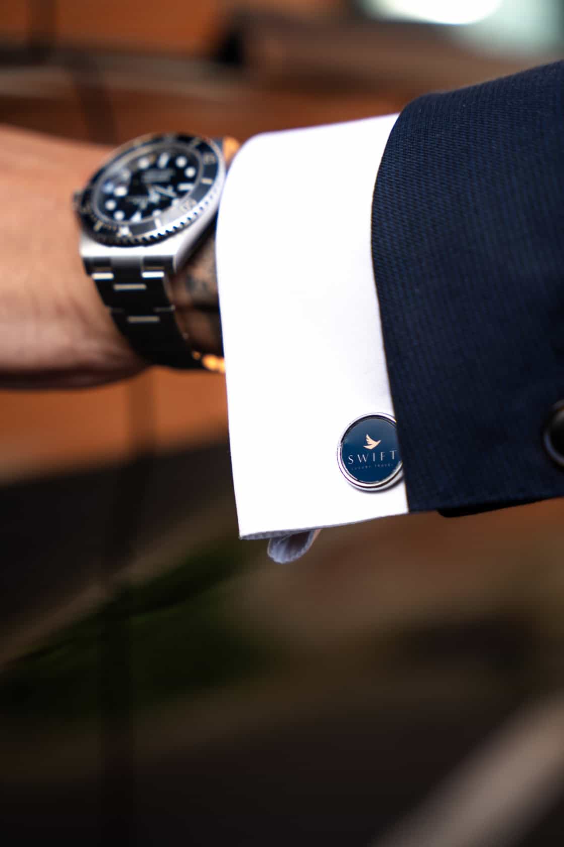 Swift Luxury Travel-65 Close-up of a luxury watch on a man's wrist with a Swift Luxury Travel cufflink.